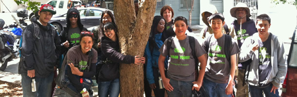 Members of the Green Teens program posing outdoors with a tree